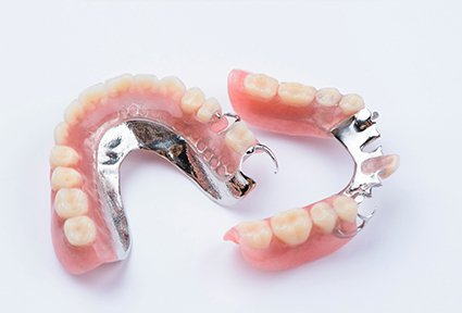 Set of partial dentures with metal on a white background