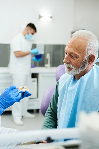 Dentist discussing treatment with patient using model teeth