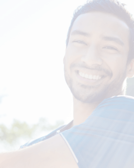 Young man grinning outdoors on sunny day