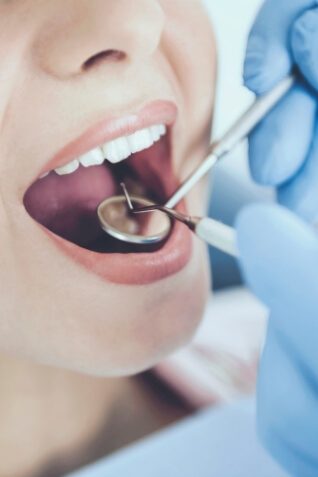 Woman having her mouth examined by dentist