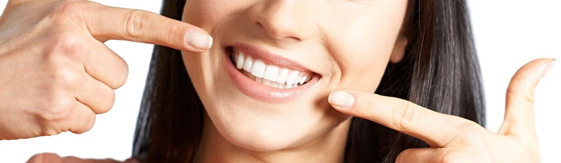 Dentist Yarmouth ME Close Up on Woman Smiling While Pointing to Her Teeth Close Up on Woman Smiling While Pointing to Her Teeth